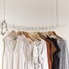 white brown and grey shirts hanging on a rack against a white wall