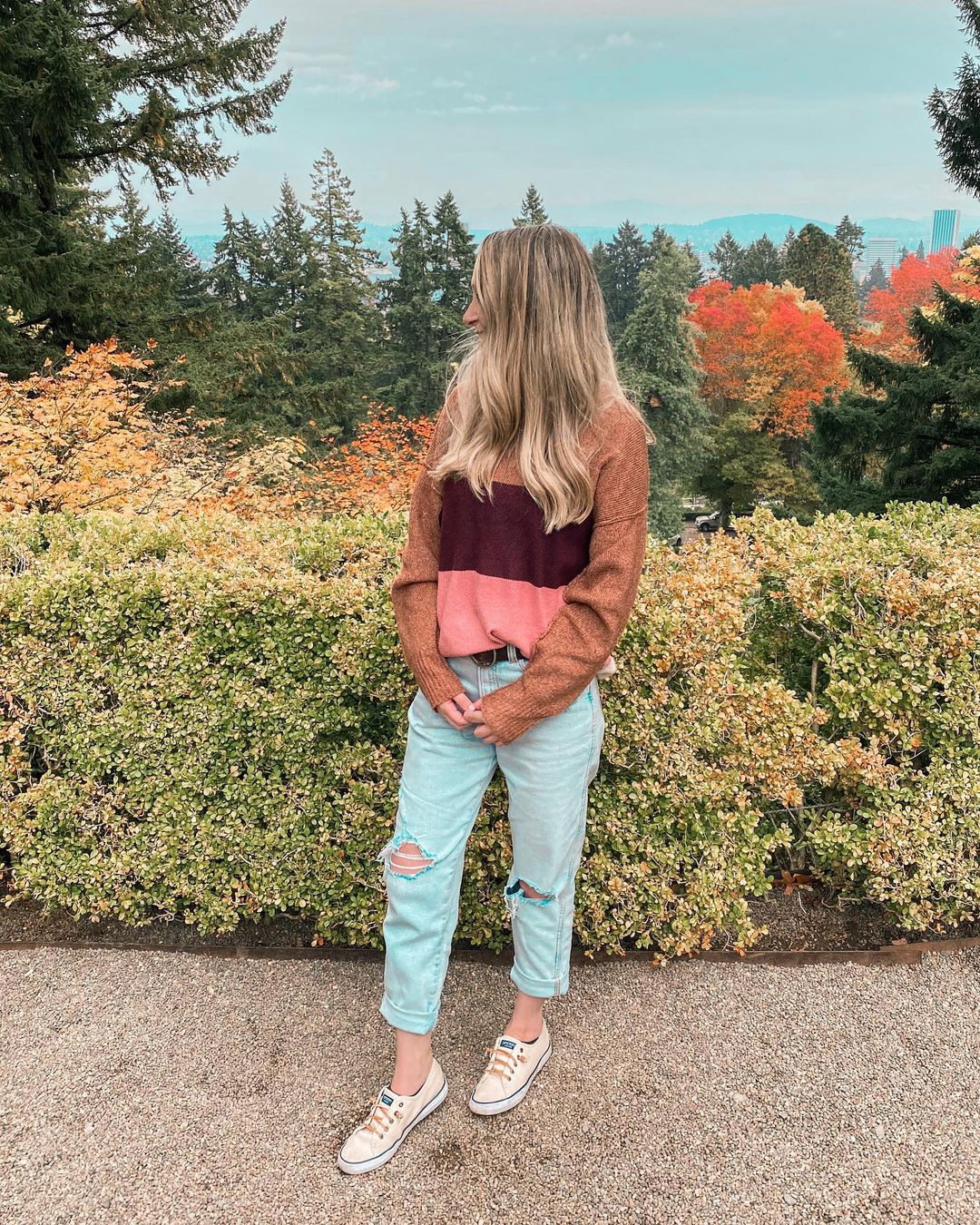 Fall colors sweater with ragged cropped jeans and white sneakers